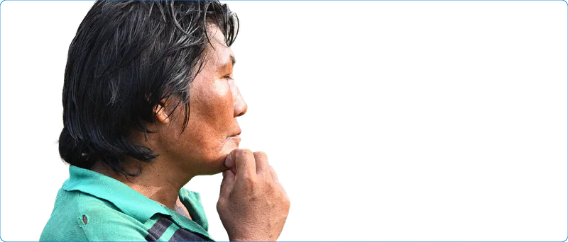 Mujer indígena de perfil, con camiseta verde y la mano apoyada en el mentón.