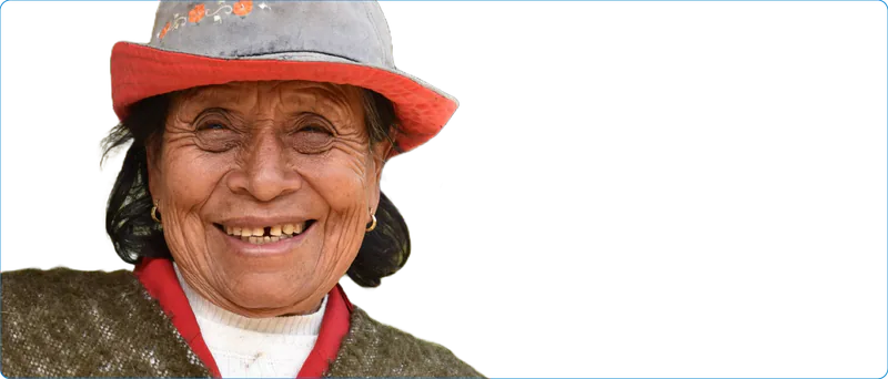Mujer campesina mayor sonriendo, con sombrero de ala roja y ruana.